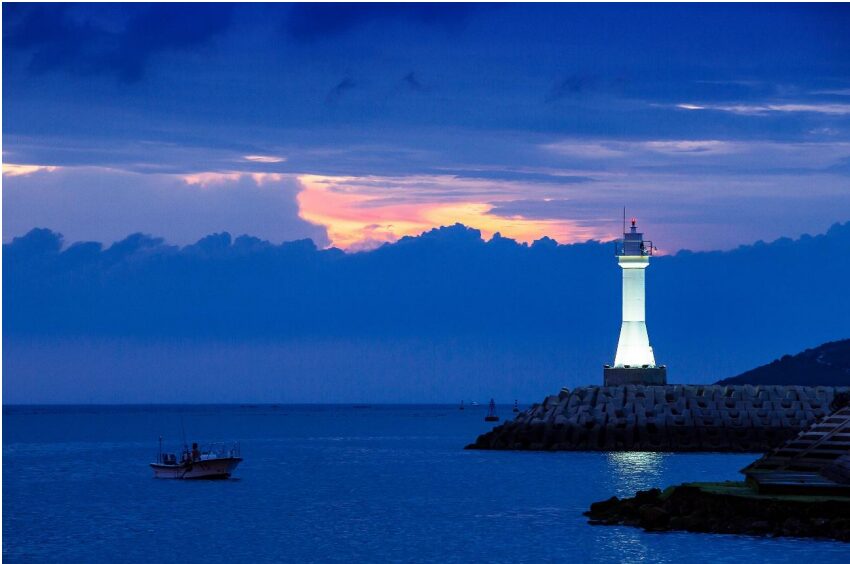 Atardecer con un faro iluminado