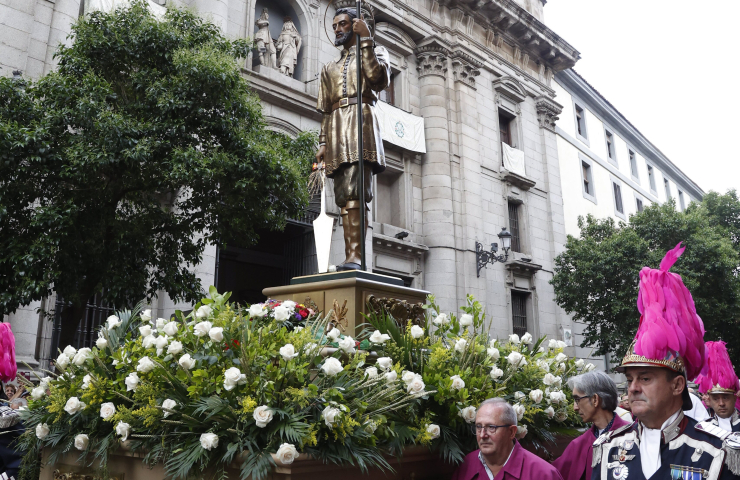 Procesión de San Isidro en la calle con un paso decorado con flores