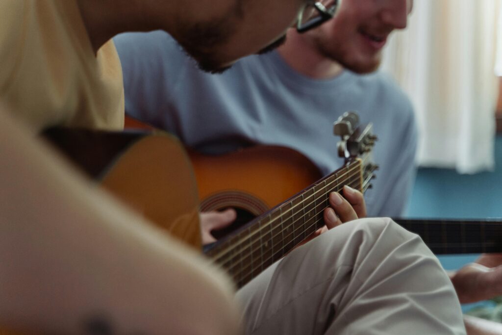 dos personas jóvenes tocando la guitarra