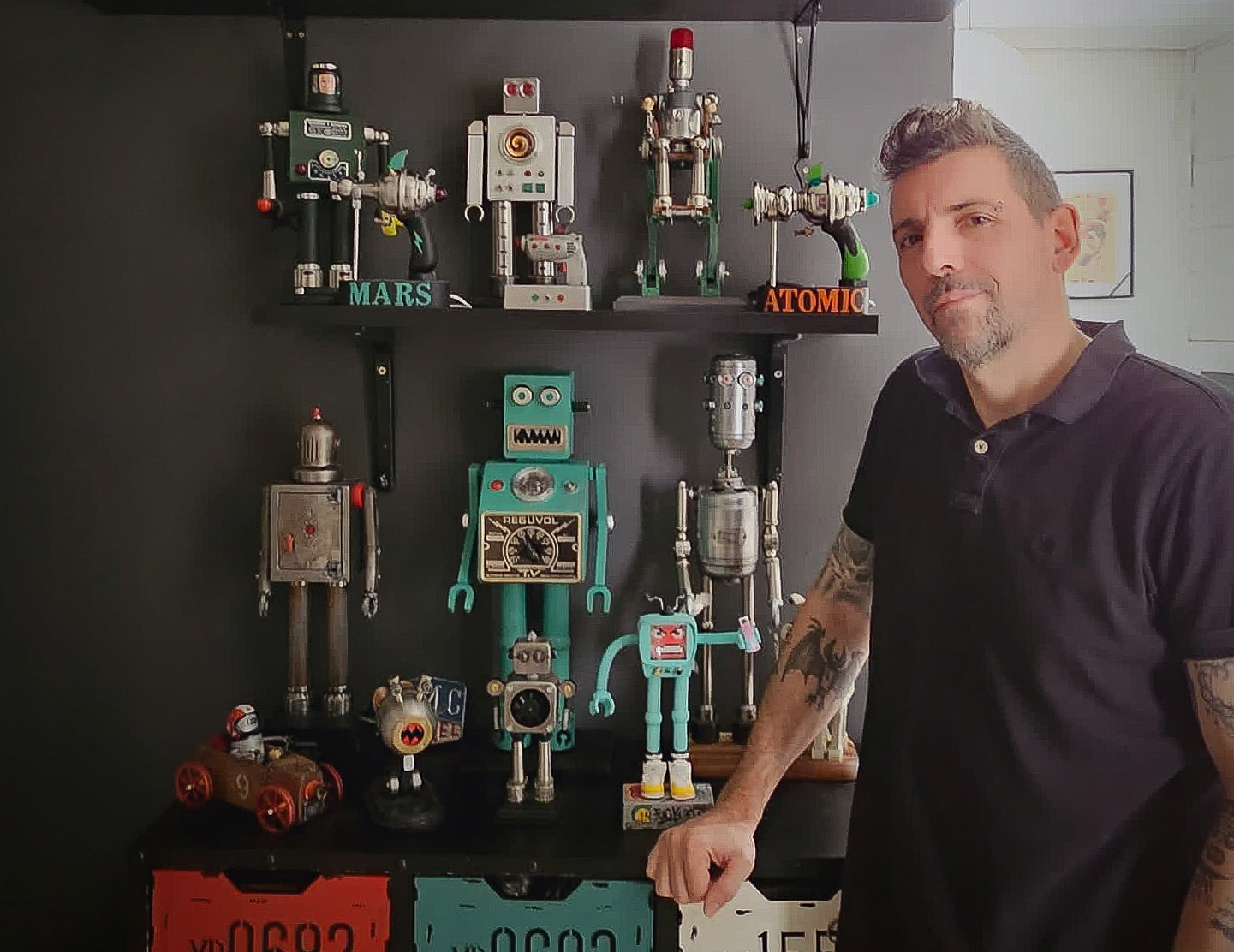 Foto de Juan Andrés Guardia y su exposición 'Robots retrofuturistas' donde aparece el autor con varias de sus obras