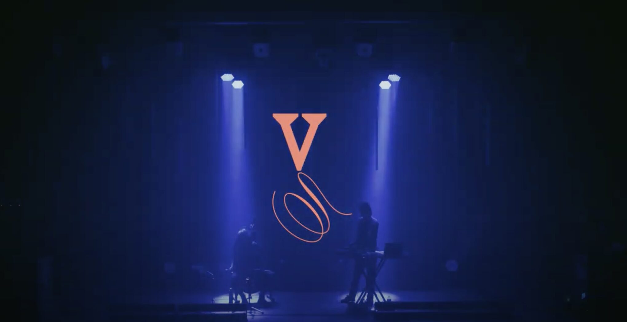Escenario iluminado en azul con siluetas de Lucile Boulanger y Calling Marian durante el espectáculo Versailles.