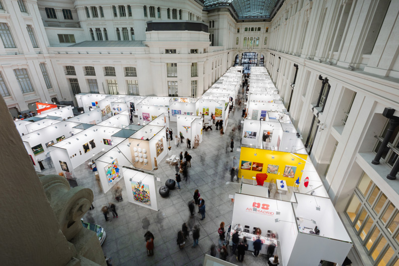 Vista panorámica del interior de la feria de arte contemporáneo Art Madrid con stands y visitantes